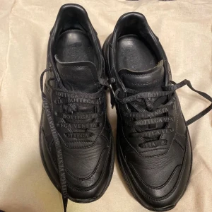 Svarta sneakers från Bottega Veneta - Säljer ett par svarta sneakers från Bottega Veneta. Skorna är helt i skinn. Säljer billigt pga hade personalrabatt och har inte kvar kartong osv. Skorna är enbart använda inomhus. Perfekta för dig som vill ha en stilren och lyxig look.