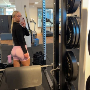 Ljusrosa seamless träningsshorts från DFyne - Säljer ett par ljusrosa seamless träningsshorts från DFyne. De har hög midja och är tillverkade i ett stretchigt syntetmaterial som sitter tight och bekvämt. Perfekta för gymmet eller annan träning. Snygg och enkel design med logga framtill. Använda en gång!