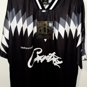 Jersey | Corteiz - Unik och eftertraktad jersey från Corteiz med sportig design och streetwear-vibe. Helt ny, aldrig använd och med lappar kvar. Perfekt för dig som vill sticka ut med stil! (FÖRST TILL KVARN)