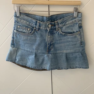 Ljusblå jeanskjol med volangkant - Säljer en kort ljusblå jeanskjol med volangkant nertill, som jag själv har sytt. Den har aldrig använts och är typ som nyskick. Inte säker på storleken men skulle säga S🩷Kan tyvärr inte visa bild på då den är för liten💕