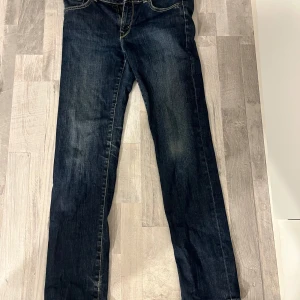 Mörkblå jeansbyxor med raka ben - Säljer ett par mörkblå jeans med raka ben och kontrastsömmar. Byxorna passar som xs/s storlek.