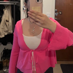 Rosa knytblus från SHEIN - Säljer en superfin rosa blus från SHEIN med knyt framtill och långa, vida ärmar. Aldrig använd.