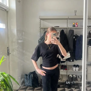 Svart croppad t-shirt från Gina Tricot - Säljer en svart croppad t-shirt från Gina Tricot. T-shirten har korta ärmar och en enkel, klassisk design med rund halsringning. Perfekt till jeans eller kjol för en avslappnad look. Använd få gånger och har inga fläckar eller hål❣️ 