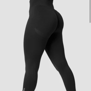 Svarta seamless tights från ICIW - Säljer ett par svarta seamless tights från ICIW med hög midja och tight passform. Perfekta för träning med snygg shaping-effekt och diskret logga vid vaden. Superstretchigt material som sitter på plats under hela passet.