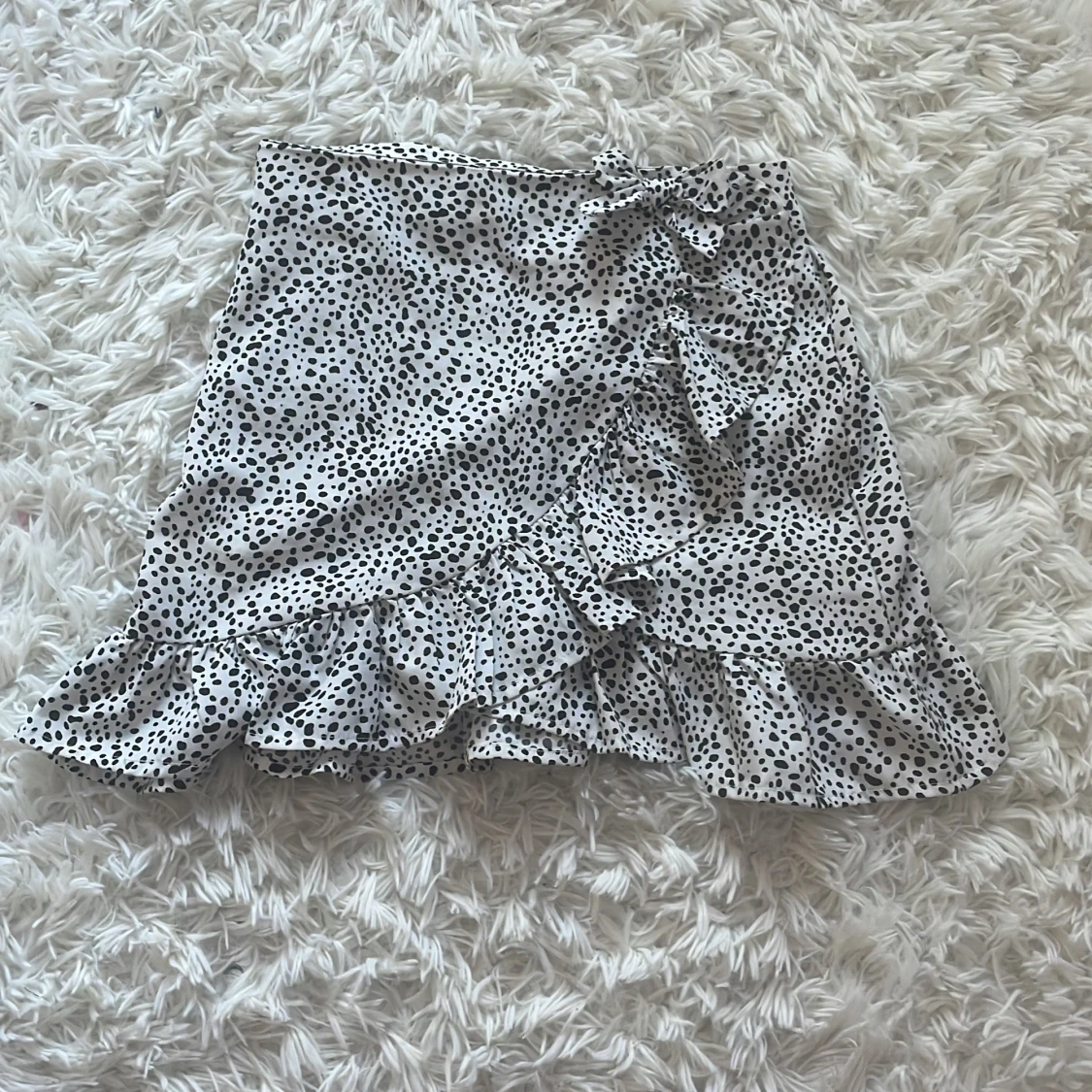 Prickig omlottkjol med volang och rosett