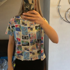 Färgglad comic t-shirt från Zara - T-shirt från Zara med coolt serietidningsmönster i flera färger som blått, rött, svart, beige och grönt. Modellen är kortärmad och har en avslappnad passform. Perfekt för dig som vill sticka ut med en unik och lekfull stil.🩵