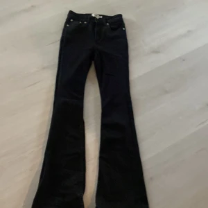 Svarta bootcut jeans från 157, S - Svarta jeans från 157 i bootcut-modell med klassisk femficksdesign och dragkedja. Jeansen har hög midja och är tillverkade i ett stretchigt bomullsmaterial som sitter snyggt och bekvämt. Perfekta för dig som gillar en retroinspirerad look.