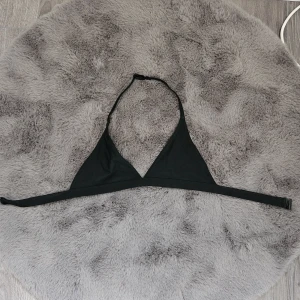 Svart trekantsbikini topp - En stilren svart trekantsbikini med smala band som knyts i nacken och runt ryggen. Klassisk modell utan mönster, perfekt för stranden eller poolen. Materialet känns mjukt och följsamt mot huden. Säljer pga att den är för liten 