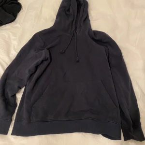 Svart hoodie från Brave Soul - En klassisk svart hoodie från Brave Soul i storlek S med huva och snörning. Tröjan har en stor magficka och ribbade muddar vid ärmslut och nederkant. Perfekt för chill dagar eller när du vill ha en enkel och stilren look.