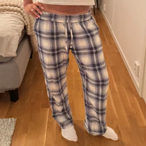 Rutiga mjukisbyxor med snörning XS - Supermysiga mjukisbyxor från 157 i blått och vitt rutigt mönster. Byxorna har dragsko i midjan och är raka i modellen, perfekta för chill dagar hemma. Tillverkade i mjukt bomullstyg för extra komfort.💖