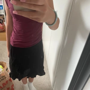 Svart medellång kjol med volangkant - Svart knälång kjol med volangkant längst ner. Kjolen har knytband i midjan och är o strl 146-152 men passar även mig som har strl XS ❤️