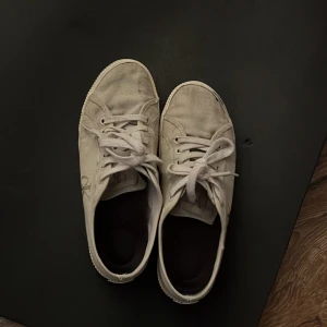 Beigea  Calvin Klein sneakers med snörning. Nya kostar 1500 - Snygga beigea sneakers från Calvin Klein med klassisk låg profil och rund tå. Skorna har tydlig CK-logga på sidan, snörning framtill och platt sula. Tillverkade i textil med gummisula, perfekta för en clean och stilren look.