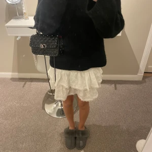 Vit volangkjol med broderade blommor - Supersöt vit kortkjol med volanger och broderade blommor. Kjolen har en luftig känsla. Resår i midjan gör den bekväm och enkel att bära. Passar perfekt till sneakers eller sandaler. Toppen till sommaren.