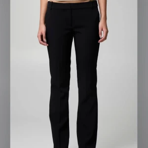 Lågmidjade Kostymbyxor  - Lågmidjade Kostymbyxor från Bikbok. Byxorna är lite stora på mig som vanligtvis har storlek 36/W27 men passar mig perfekt i längden (163cm), men passar troligen upp till 170cm. Köpte byxorna för 500kr men säljer billigt då de saknar en knapp (Dock inget som märks eller syns alls då det finns två till) och att de är lite slitna vid fötterna då jag troligtvis trampat på dom (inget man tänker på heller). Önskas bild på detta skriv privat!🩷