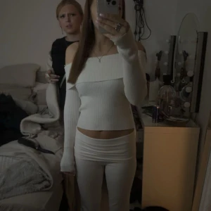  stickad tröja - Säljer en superfin vit stickad tröja med ribbad struktur och offshoulder-modell. Tröjan har långa ärmar och sitter snyggt figurnära. Perfekt för dig som gillar en stilren och trendig look.