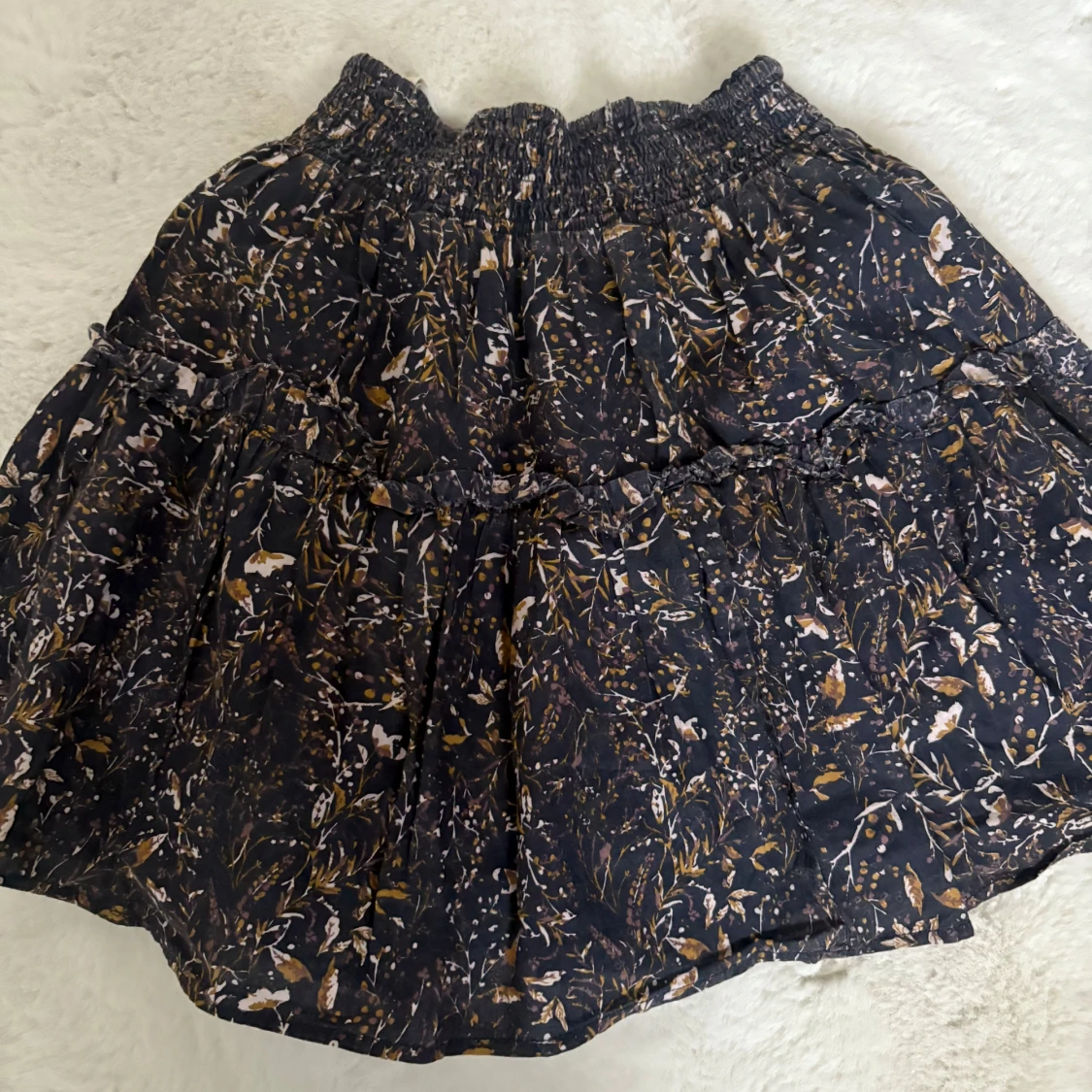 Svart blommig kortkjol med volang