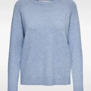 Ljusblå stickad tröja - Supermjuk ljusblå stickad tröja med rund hals och långa ärmar. Enkel och stilren design som passar perfekt till jeans eller kjol. Tröjan har ribbade muddar vid ärmslut och nederkant för en snygg finish.