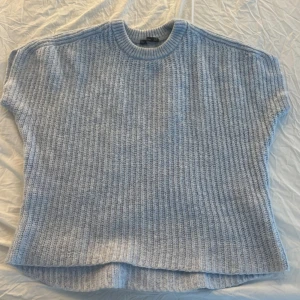 Ljusblå stickad tröja från Zara - Säljer en ljusblå stickad tröja från Zara. Tröjan har en ribbad struktur och korta ärmar, perfekt för lager-på-lager under kyligare dagar. Den har en rund halsringning och en avslappnad passform. Pris kan diskuteras 💗