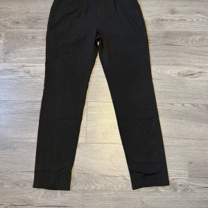 Svarta byxor från Jack & Jones - Snygga svarta byxor från Jack & Jones med en klassisk design. Perfekta för en stilren look. Byxorna har en knappstängning och är tillverkade i ett bekvämt material.