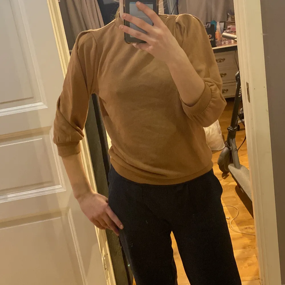 Säljer en snygg brun tröja från Vero Moda. Tröjan har en hög krage och trekvartsärmar med puffiga axlar. Perfekt för en stilren look. Passar bra till både jeans och kjol. Pris kan diskuteras. Neuletakit & Villapaidat.