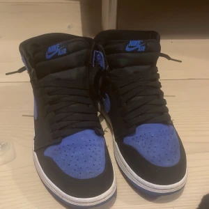 Nike Air sneakers i svart och blått - Snygga Nike Air sneakers i en cool kombination av svart och blått. Skorna har en klassisk design med snörning och en bekväm passform. Perfekta för dig som vill ha stil och komfort i ett.