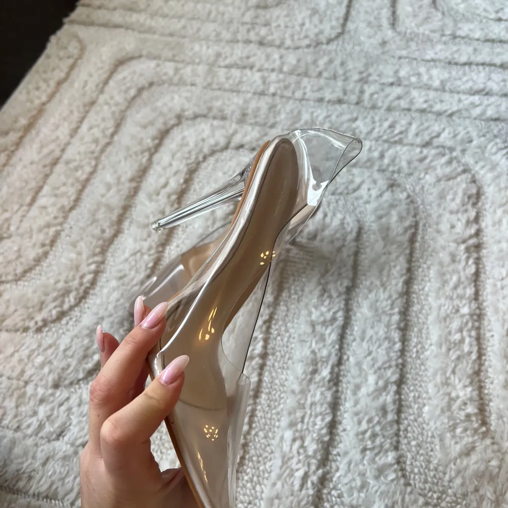 Snygga transparenta klackskor med spetsig tå och hög klack. Perfekta för att ge en elegant touch till din outfit. Skorna har en modern design med en genomskinlig finish. Oanvända men en del av klacken saknas. . Kengät.