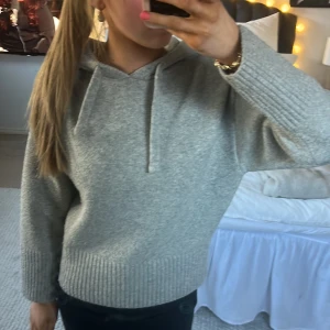 Grå stickad hoodie - Säljer en mysig grå stickad hoodie med ribbade detaljer vid ärmslut och nederkant. Perfekt för kyliga dagar. Den har en bekväm passform och en klassisk huva med dragsko. Hoodien är från zara och använt få gånger så den är som ny! Skriv vid frågor och funderingar!💕!priset kan diskuteras vid snabb affär!