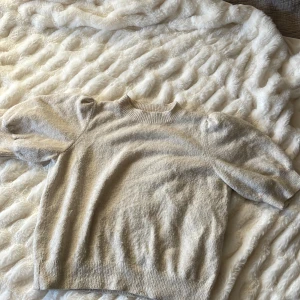 Beige tröja från Vero Moda - Säljer en mysig beige tröja från Vero Moda. Tröjan har en rund halsringning och korta(lite puffiga) ärmar. Perfekt för en stilren och bekväm look. Passar bra till både jeans och kjol.