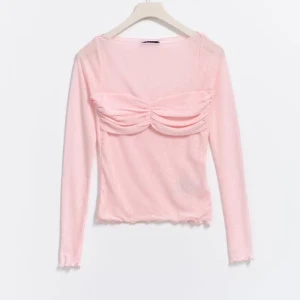 Rosa långärmad topp med rynkdetalj - Säljer en söt rosa långärmad topp med rynkdetalj vid bysten från Gina Tricot. Toppen har en mjuk och stretchig passform med vågiga kanter vid ärmslut och nederkant. Endast använd en gång💕