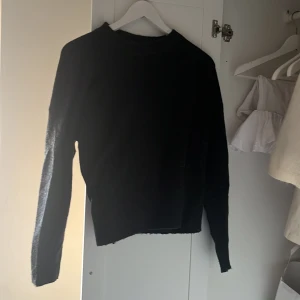 Mörkgrå/Svart stickad tröja från Uniq Studio str 146/152 - Säljer en stilren mörkgrå/svart stickad tröja från Uniq Studio i str 146/152. Tröjan har en klassisk design med långa ärmar och ribbade muddar. Perfekt för kyligare dagar. Passar bra till både jeans och kjol. 🖤