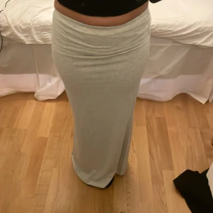 Grå långkjol - Snygg och bekväm grå långkjol i mjukt material. Perfekt för en avslappnad stil. Kjolen har en bred linning som kan vikas ner för en personlig passform.