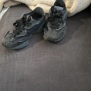 Svarta sneakers från New Balance - Säljer ett par svarta sneakers från New Balance med en unik design. Skorna har snörning och en robust sula som ger bra grepp. Perfekta för både vardag och träning. Jätte bekväma och mycket passande för sommaren då de släpper igenom luft. 
