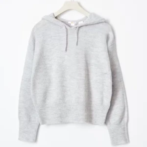 Grå stickad hoodie - Säljer en mysig grå stickad hoodie med långa ärmar och ribbade muddar. Perfekt för kyliga dagar. Den har en klassisk huva med dragsko för extra komfort.