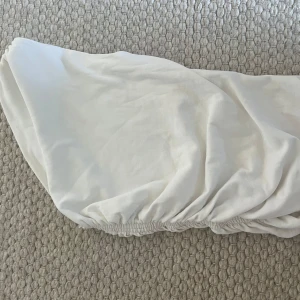 Vit bandeau tubtopp med smock - Säljer en vit bandeau tubtopp med smockad resår vid midjan och uppe vid axeln