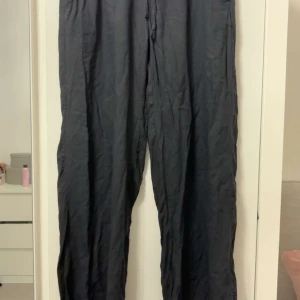 Svarta linnebyxor från Lager 157 XS - Svarta linnebyxor från Lager 157 i storlek XS. Byxorna har en loose passform med rak siluett och snörning i midjan för extra komfort. Perfekta för chill dagar och har en enkel, stilren look som funkar till många outfits. Dock har de krympt i tvätten, så de är lite kortare än vanligt.