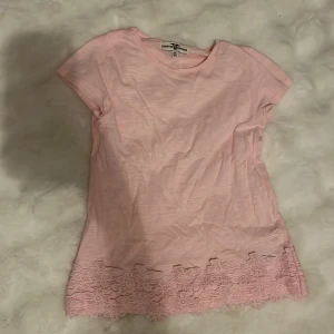 Rosa topp med spets från Hampton Republic - Supersöt ljusrosa topp från Hampton Republic. Nedtill finns en bred kant av matchande spets som ger en extra fin detalj. Säljer pga att den tyvärr blivit för liten för mig. Står att den är stl 134/140, men skulle passa någon som har XXS. Inte mycket använd och inga defekter, hör av er om frågor!