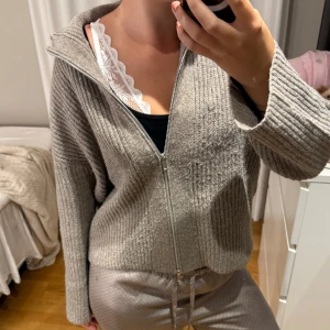 Beige stickad tröja - Mysig beige stickad cardigan tröja med dragkedja framtill och långärmad modell. Det är ett liten hår under armhålan, men inget som syns