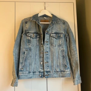 Klassisk ljusblå jeansjacka - Säljer en klassisk ljusblå jeansjacka med snygga sömmar och silverfärgade knappar. Jackan har två bröstfickor med lock och knappar samt två sidofickor. Perfekt oversized fit och tidlös stil som passar till allt.