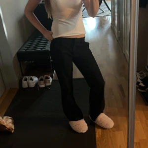 Svarta kostymbyxor från Nelly - Snygga svarta kostymbyxor från Nelly med raka ben och klassisk passform. Byxorna har hällor för bälte, diskreta bakfickor och stängs med dragkedja och knapp. Perfekta till en stilren look och funkar året runt. Inga defekter och pris kan alltid diskuteras 💕