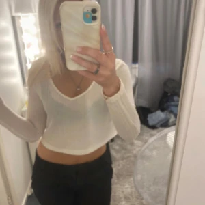 Vit croppad ribbad tröja - Säljer en vit croppad tröja med ribbad struktur och v-ringad hals. 