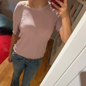 Ljusrosa/ lila  topp från Lindex - Enkel och snygg ljusrosa topp från Lindex med korta ärmar och rund halsringning. Modellen är loose fit och passar perfekt till jeans eller kjol. Mjuk och skön i bomullsmaterial, perfekt för vår och sommar.