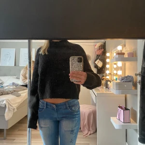 Svart croppad stickad tröja - Säljer en svart croppad stickad tröja med lång ärm och hög hals. Tröjan har en loose passform och är perfekt nu till vintern.