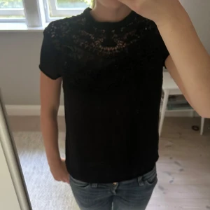 Svart blus med spetsdetaljer - Supersnygg svart blus med korta ärmar och vacker spets upptill. Vet inte storlek eller märke men skulle säga att den är XS/S. Nyskick. Skriv  vidfrågor💕