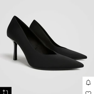 Svarta pumps från Stradivarius  - Säljer ett par stilrena svarta pumps med spetsig tå och smal klack. Skorna har en elegant siluett och är tillverkade i ett slätt syntetmaterial som ger en modern vibe. Endast använda 1 gång!