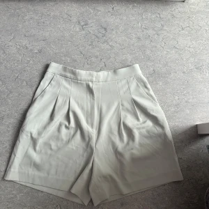 Ljusgröna shorts från H&M - Oanvänd. Skickar iväg samma dag eller dagen efter🙌🏼Snygga ljusgröna shorts från H&M i storlek S. har pressveck fram och diskreta fickor bak. Materialet är mjukt och känns som en blandning av polyester och bomull, perfekt för varma dagar.
