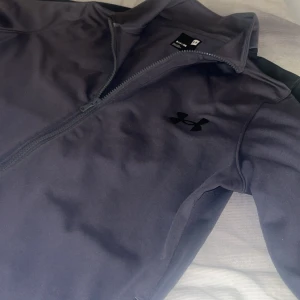 Svart träningsjacka från Under Armour - Under Armour kofta knappt använd i grå färg storlek S ganska fin och unik 