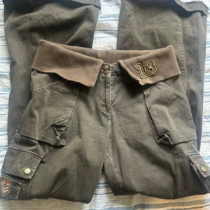 Supercoola lowwaisted cargo byxor  - Supercoola och unika lowwaisted cargobyxor, de sitter supersnyggt tack vare vikningen i midjan, är verkligen 00s.  Kommer tyvärr inte till så mycket användning för mig, men är i super skick💕