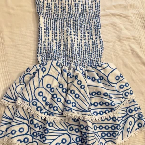 Vit och blå kortklänning med spets - Supersöt kortklänning i vitt med blått Materialet känns lätt och luftigt.  Den är lite Stor i S skulle jag säga den var lång på mig KÖPT PÅ VINTED men vet ej vart den e ifrån 