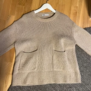 Beige stickad tröja från Zara - Säljer en gullig stickad tröja med fickor då ja har beställt en lika dan fast i svart satt rensar ut lite!!💕 Storlek M men skulle passa S oxå, lite nopprig men inget märkbart när man har på sig den!!