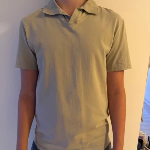 Beige t-shirt med krage från Filippa K - Snygg beige t-shirt från Filippa K i storlek S. Modellen har klassisk krage och korta ärmar, perfekt för en clean och chill stil. Tillverkad i mjuk bomull som känns skön mot huden. Enkel design utan mönster eller detaljer, passar dig som gillar minimalistiskt. Nypris 800kr använd 3 gånger!